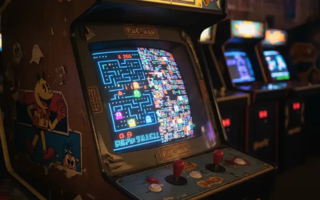 Gabinete de arcade clássico exibindo a tela dividida com erro visual do nível 256 de Pac-Man.