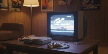 Console PlayStation original de 1997 exibindo o jogo Gran Turismo em uma TV de tubo antiga