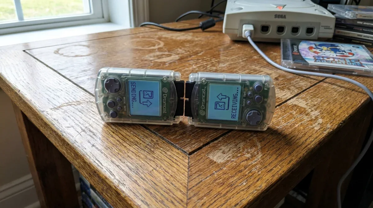Dois cartões de memória VMU do Dreamcast conectados frente a frente para troca de arquivos.