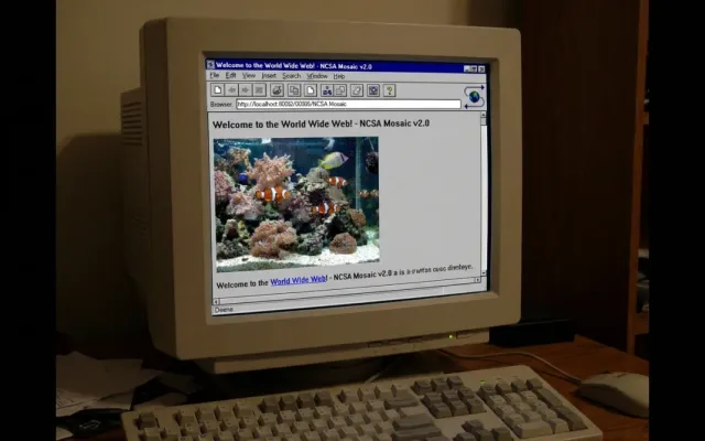 Monitor de tubo antigo dos anos 90 exibindo o navegador Mosaic com uma imagem de peixe em aquário