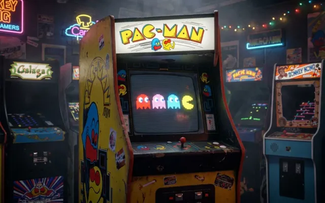 Gabinete de arcade clássico de Pac-Man iluminado em uma sala de jogos retrô.